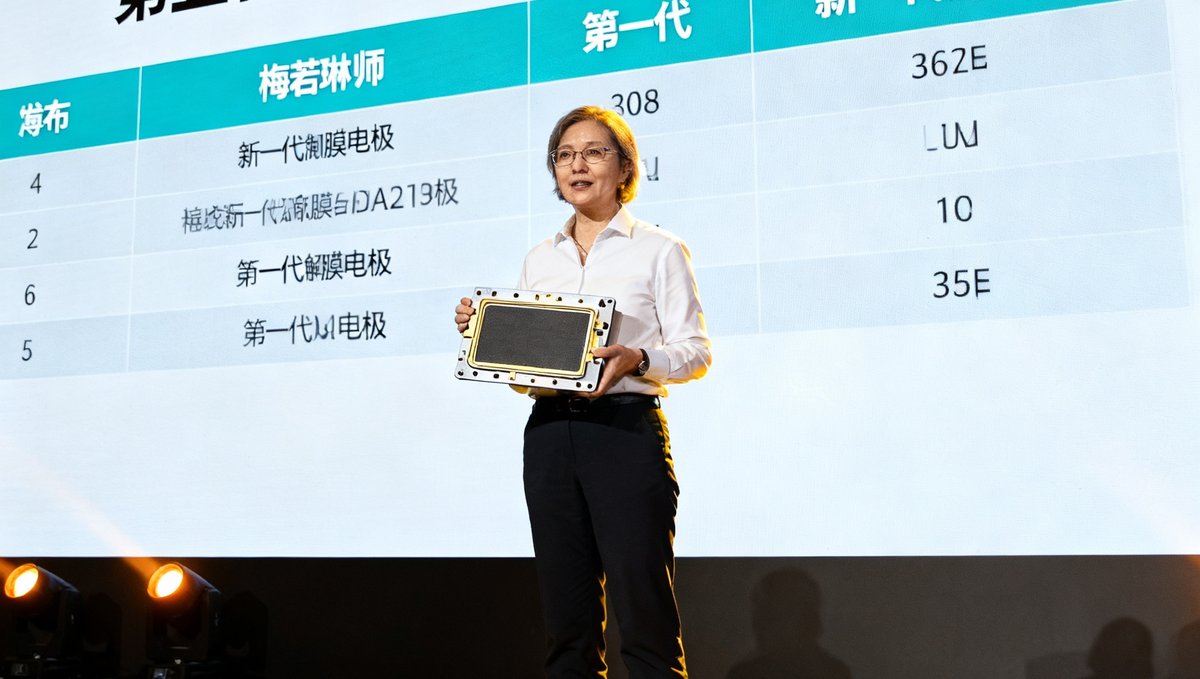 第五代PEM电解槽产品发布会现场，梅若琳博士在台上展示新一代膜电极组件，大屏幕显示技术参数。